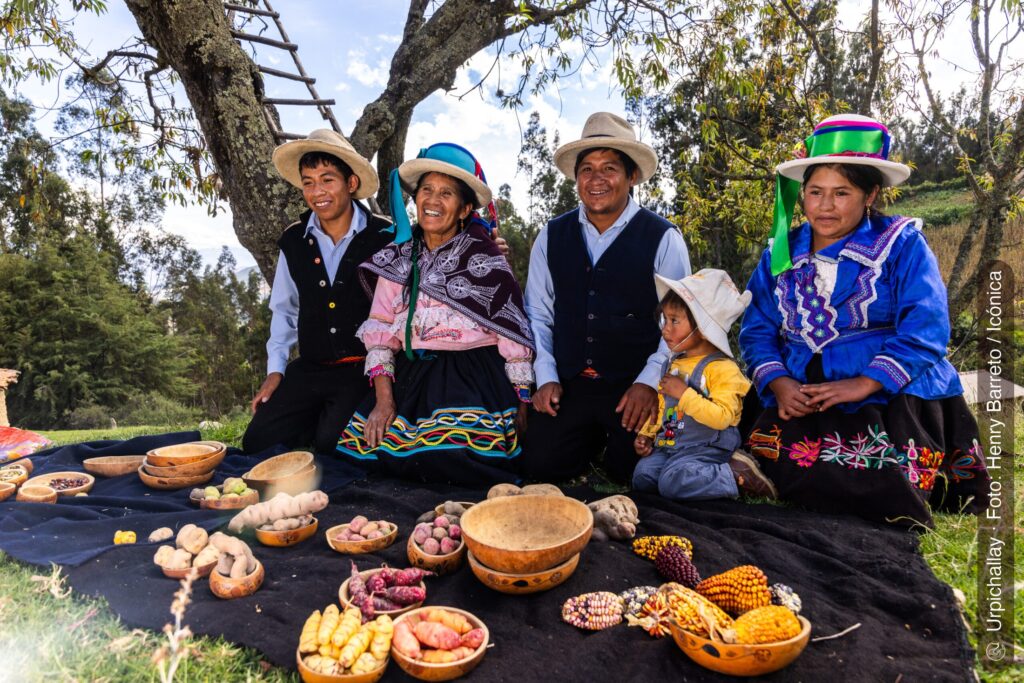 Familia campesina mostrando variedades de papa nativa y maíz en Áncash