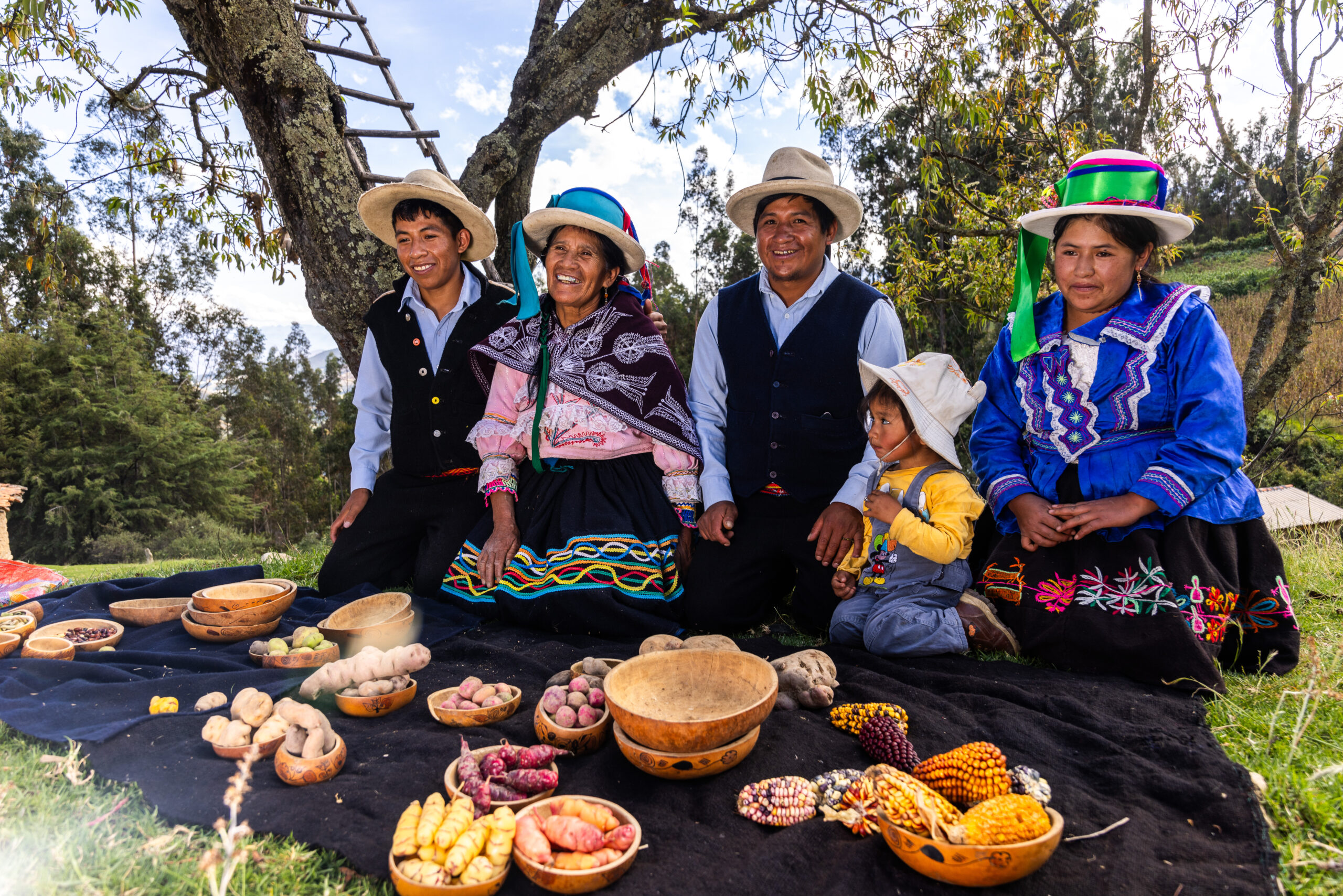 Familia campesina de Áncash junto a una muestra de papas nativas y mazorcas de maíz.